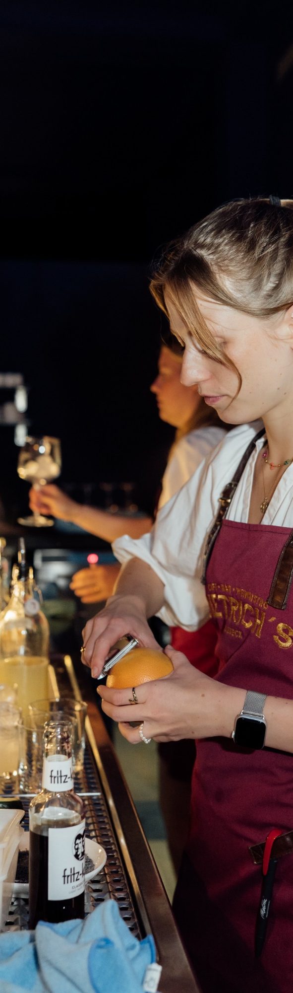 Charlotte und Lotte an der Bar, um alle mit Cocktails zu versorgen
